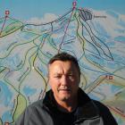 Coronet Peak Ski Area manager Hamish McCrostie stands in front of a map of the ski area's trails....