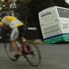 Cyclists competing in the Otago junior cycling championships pass an Intercity bus which slipped...