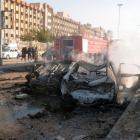 Damaged cars are seen at the site where two explosions rocked the University of Aleppo, killing...