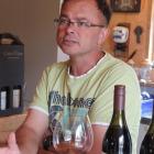 Dan Asher and his savoury pinot noir from Swallows Crossing vineyard, which slopes  steeply down...