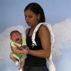 Daniele Ferreira holds her son Juan Pedro during a session this week to stimulate the development...