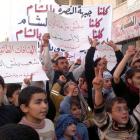 Demonstrators hold banners during a protest against Syria's President Bashar al-Assad in Binsh,...