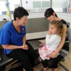 Dental therapist Mary Sayer with Evie Pennington and her mother, Micaela, at the opening of the...