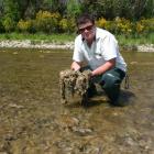 Department of Conservation freshwater ranger Pete Ravenscroft shows didymo infestation in the...