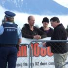 Department of Conservation principal compliance officer Alan Christie (right) issues professional...