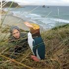 Department of Conservation ranger Mel Young places a decoy penguin on the bank above Sandfly Bay...