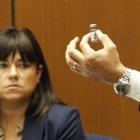 Deputy District Attorney David Walgren holds a bottle found by Los Angeles County coroner...