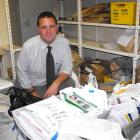 Detective Grant Miller, of Queenstown,  surrounded by  thousands of envelopes and packages...