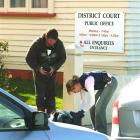 Detective Sergeant Kate Harrison searches a man's bag outside the Balclutha District Court...