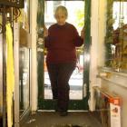 Diana Struthers examines the remains of a stained-glass door she believes was smashed by vandals...