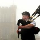 Dugald Mackay plays the bagpipes for tourists at a mist-shrouded Larnach Castle yesterday. Photo...