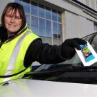 Dunedin City Council parking officer Stacey Quigley issues a Freddo Frog to a car parked in...