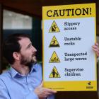 Dunedin City Council project and asset-management team leader Hamish Black with  signs which are...