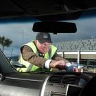 Dunedin International Airport customer services officer Peter Lunn fixes a cautionary note to a...