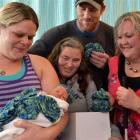 Dunedin mother Kristy Tennison tries a beanie for size on week-old Kaleb Moodie, watched by (from...