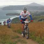 Dunedin mountain biker Jon Richardson (top) climbs Karetai track above Smails beach on the Otago...