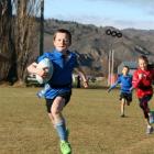 ear 3-4 Millers Flat Blue player Jock Johnson (8) bolts across the field as he is chased by St...