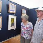 Eileen and Michael Ferns, of Invercargill, contemplate landscape paintings by Graeme Bell and...