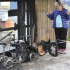 Eleanor Moore inspects the charred remains of her mobility scooter in Mosgiel on Saturday. Photo...