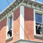 Electricians Craig Sneddon and Devon English install a camera system at 627 Castle St in January....