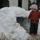 Ella Mooney (3) exits her igloo as the snow starts to melt at her family's Millers Flat property...