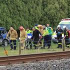 Emergency services carry the driver to the Otago Regional Rescue Helicopter at the crash scene...