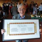 Emeritus Prof Colin Gibson displays the 2010 Library Citation he received from the Dunedin Public...
