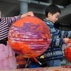 Emma Small (4) and  brother Sean (6) transform paper lamp shades into Venus-like orange planetary...