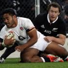 England's Manu Tuilagi is tackled by New Zealand All Blacks' Ben Smith (back) during their second...