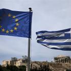 European Union (left) and Greek national flags flutter as the ancient Parthenon temple is seen in...