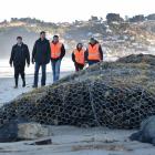 Examining storm damage on Dunedin's Middle Beach are 
...