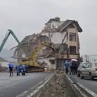 Excavators demolish the house of Luo Baogen in the middle of a newly built road in Wenling,...