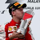 Ferrari's Sebastian Vettel celebrates with the trophy after winning the Malaysian Grand Prix....