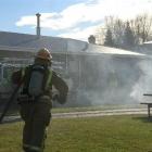 A firefighter runs towards 39 Marslin St in Alexandra with a hose at the ready during a midday...