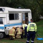 Fire Service personnel check a damaged camper van at the north end of Lake Hayes last night after...