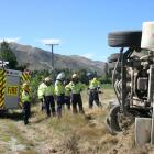 Firefighters inspect the scene after a stock truck rolled on State Highway 8A at Sandy Point...