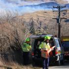 Firefighters survey the scene of  the fire above the Fruitlands area on Friday. Photo by Leith...