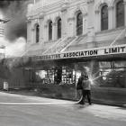 Firefighters tackle the 1969 Farmers Co-operative department store fire in Oamaru. Photo supplied.
