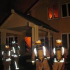 Firefighters try to save the Crown Terrace home last night. Photo by Dave Cannan.