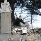 First Church caretaker Malcolm West moves the letterbox after a section of wall around the church...