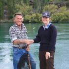 Fish and Game officer Clare Morris (right)  presents a catch net to  Ken Leckie,  who has been...