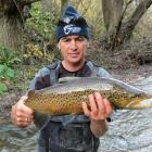 Fish and Game ranger Brent Duncan displays a trout taken from Mill Creek at Lake Hayes. Photo...