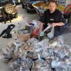 Fisheries surveillance officer Tyrone Robinson, of Dunedin, with the paua shells and meat...