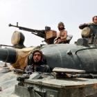 Forces of Syrian President Bashar al-Assad sit in an armoured vehicle in Qusair village near the...