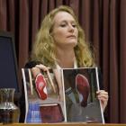 Forensic scientist Dr Anna Sandiford displays photos of bloodied feet at the Bain retrial yesterday.