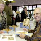 Former Dunedin City Librarian Mary Ronnie (right) signs a copy of her book Freedom to Read: A...