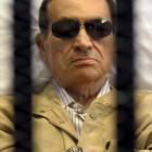 Former Egyptian President Hosni Mubarak sits inside a cage in a courtroom in Cairo in this June...