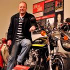 Former international motorcycle racer Graeme  Crosby (58) takes a closer look at a 1974 Kawasaki...