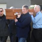 Friends and family carry the casket of Glenorchy Air senior pilot Ray Crow after a funeral...