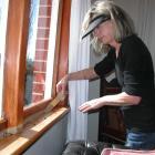 Frustrated rural dweller Sandra Hunt seals off yet more windows in her Maungati house to prevent...